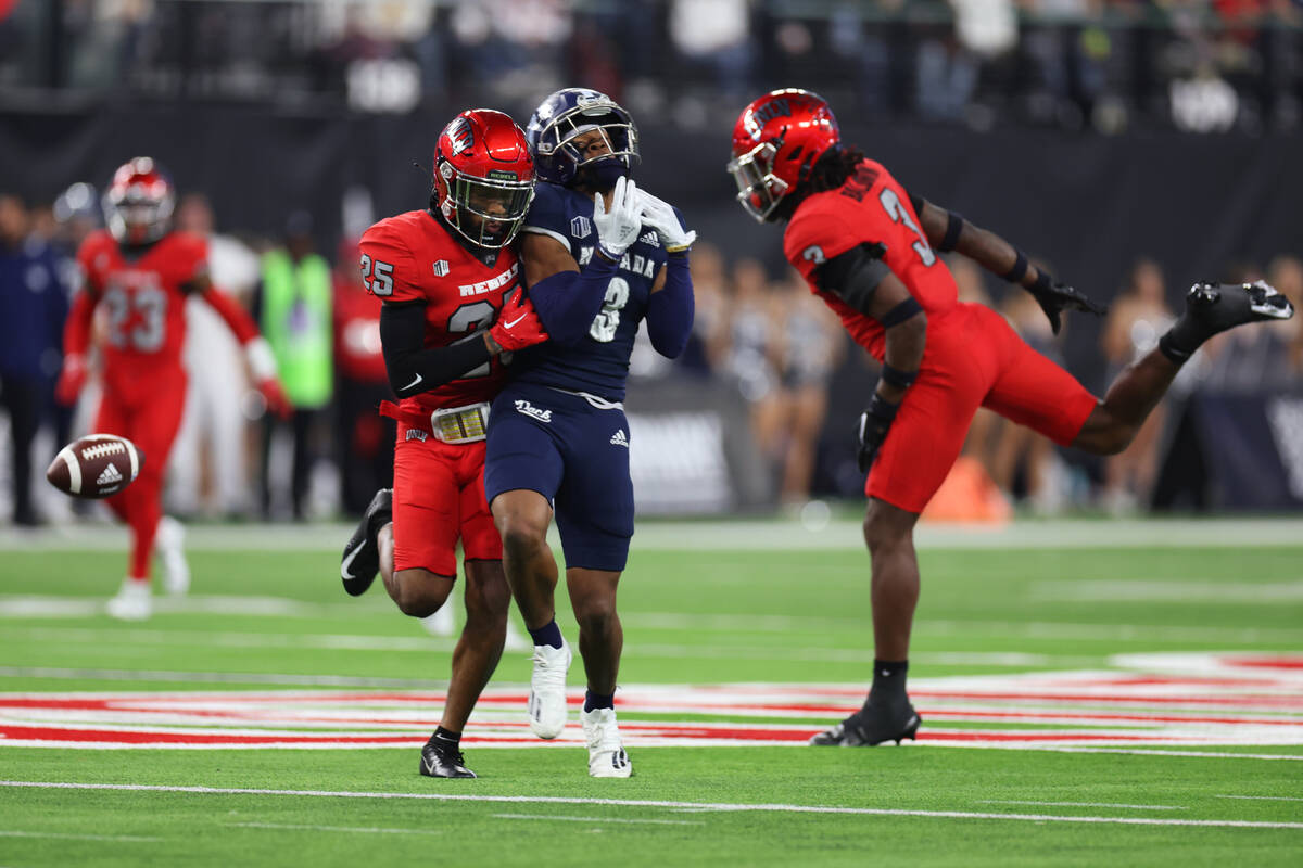 Nevada Wolf Pack wide receiver Jamaal Bell (3) makes a catch under pressure from UNLV Rebels de ...