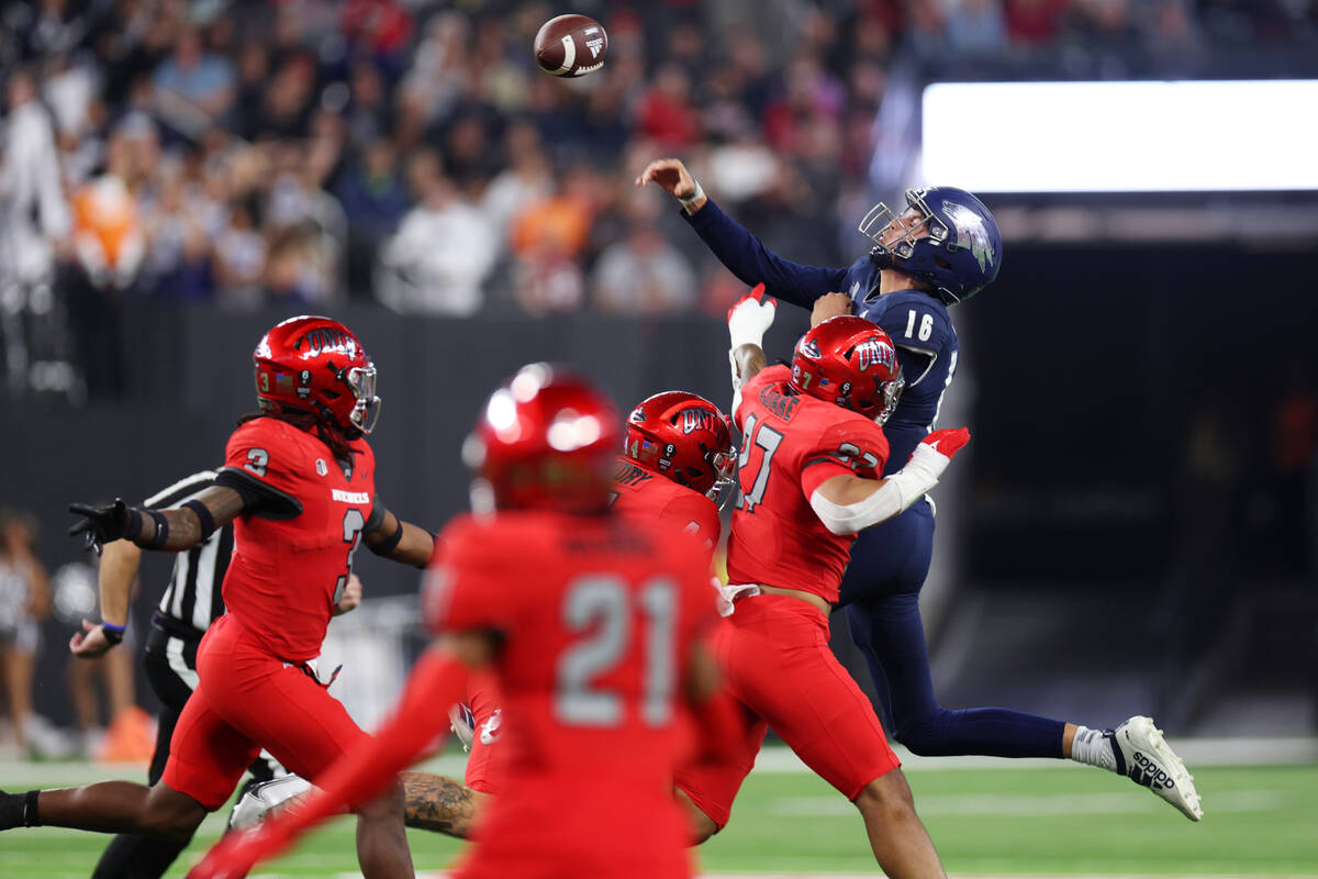 Nevada Wolf Pack quarterback Nate Cox (16) throws a pass under pressure from UNLV Rebels lineba ...