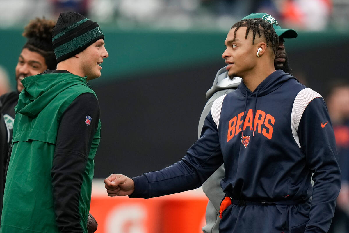 New York Jets quarterback Zach Wilson, left, talks with Chicago Bears quarterback Justin Fields ...