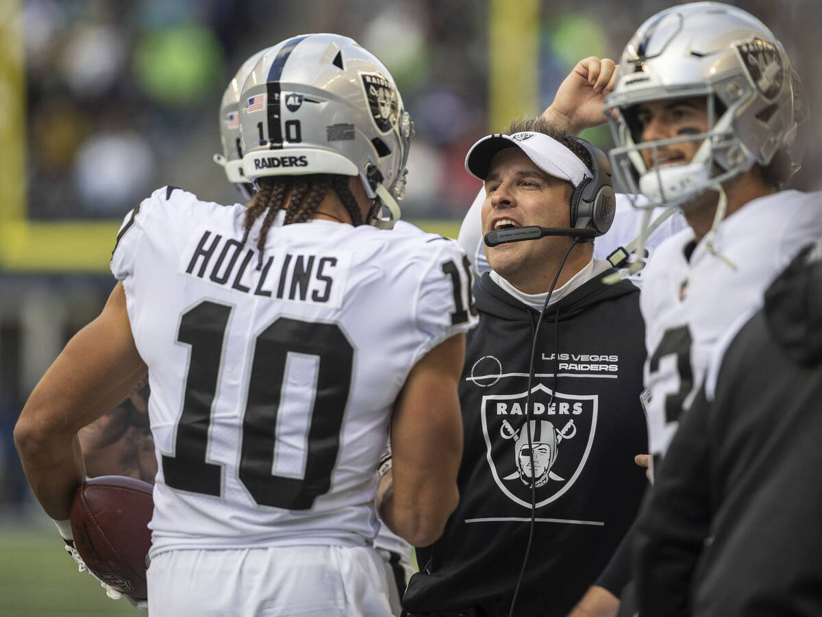 Raiders head coach Josh McDaniels congratulates Mack Hollins (10) on his touchdown during the f ...