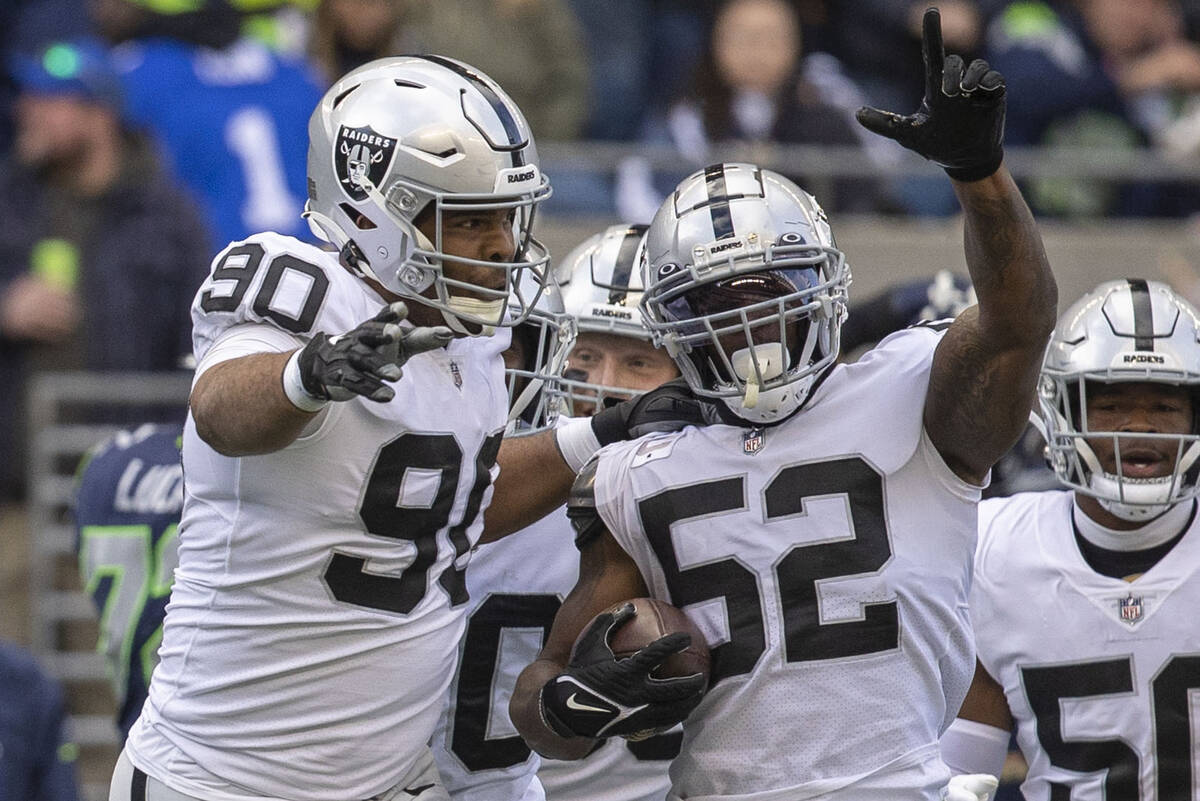 Raiders linebacker Denzel Perryman (52) celebrates his interception with defensive tackle Jerry ...