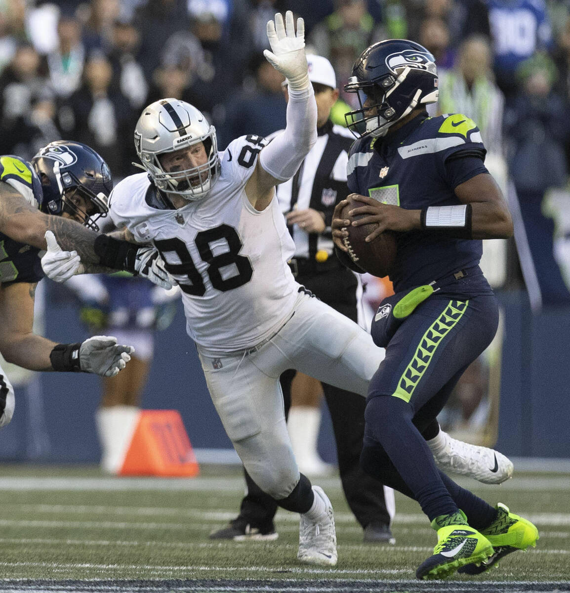 Raiders defensive end Maxx Crosby (98) looks to defend a pass from Seattle Seahawks quarterback ...