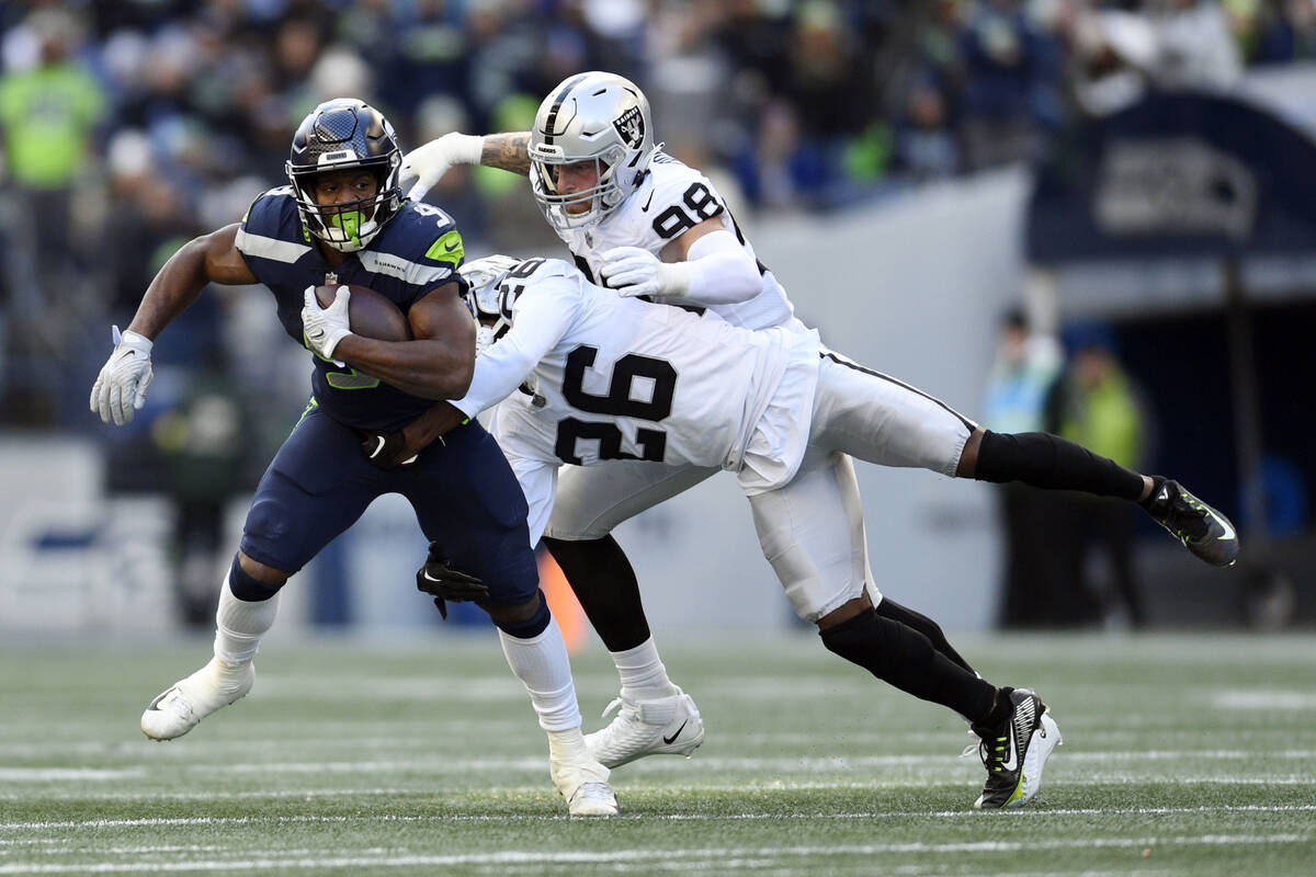 Seattle Seahawks running back Kenneth Walker III (9) runs past Las Vegas Raiders cornerback Roc ...