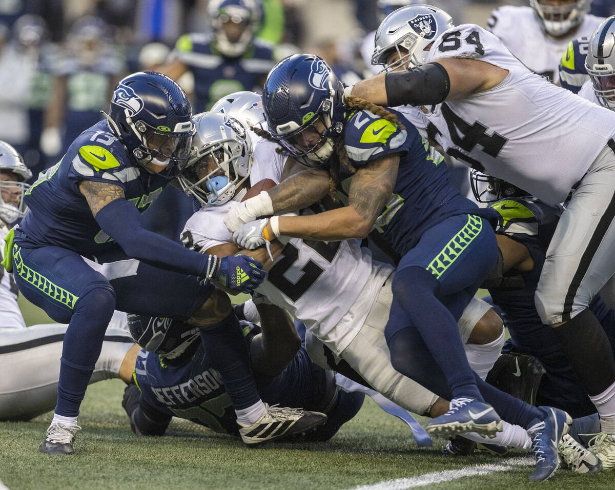 Raiders running back Ameer Abdullah (22) is tackled by Seattle Seahawks safety Josh Jones (13) ...