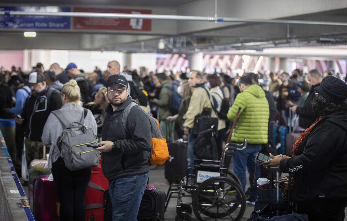 Travelers wait in the ride share area at Harry Reid International Airport on Sunday, Nov. 27, 2 ...