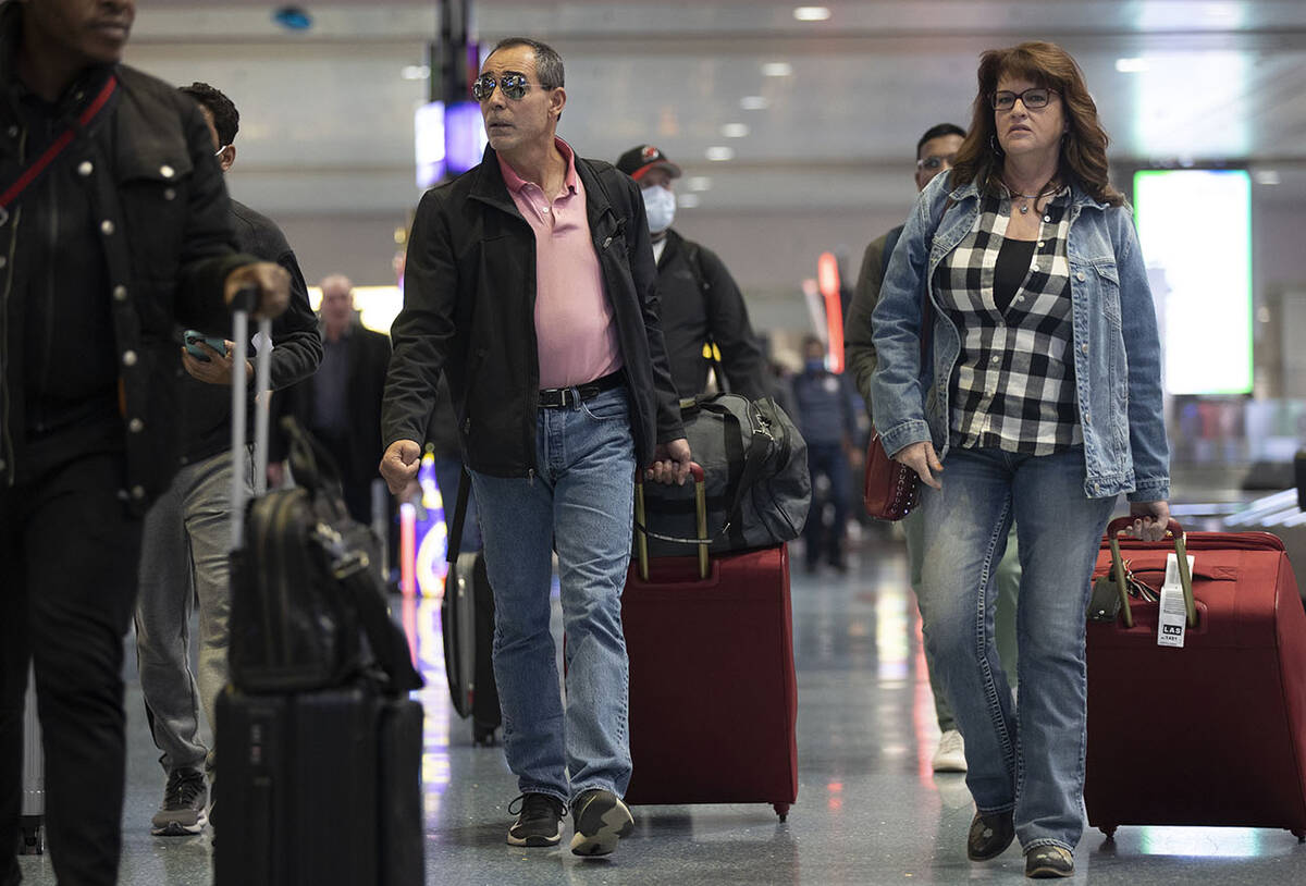 Travelers walk through terminal 1 at Harry Reid International Airport on Sunday, Nov. 27, 2022, ...
