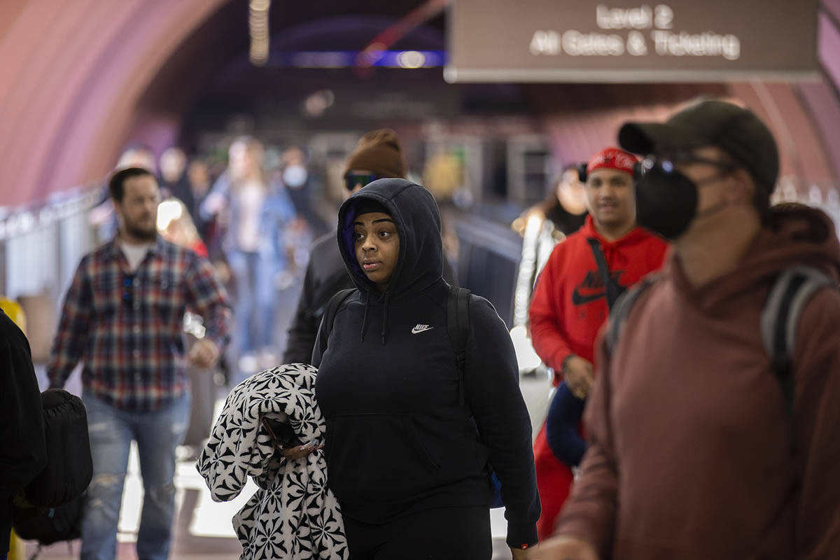 Travelers walk through terminal 1 at Harry Reid International Airport on Sunday, Nov. 27, 2022, ...