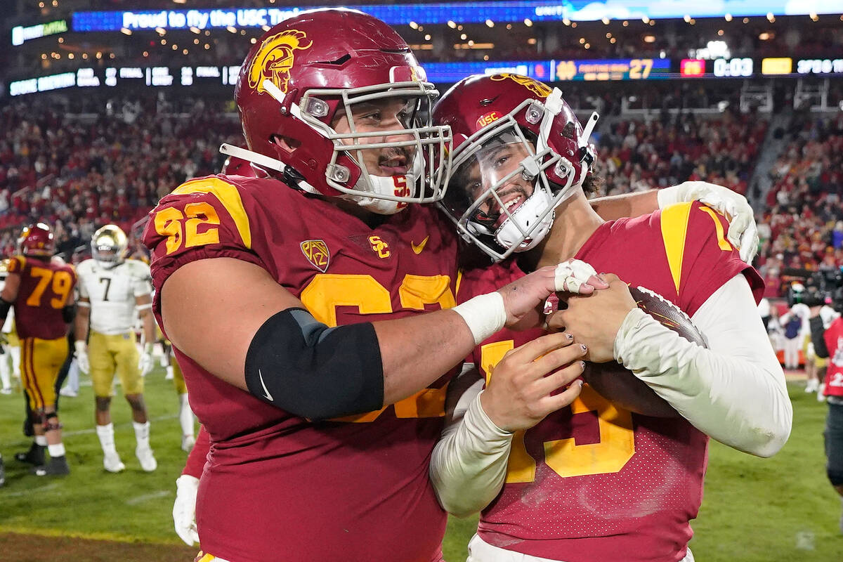Southern California quarterback Caleb Williams, right, gets a hug from offensive lineman Brett ...