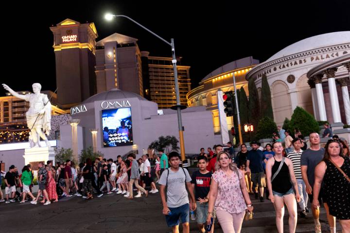 Crowds cross Las Vegas Boulevard outside Caesars Palace on the Las Vegas Strip, Tuesday, Aug. 2 ...