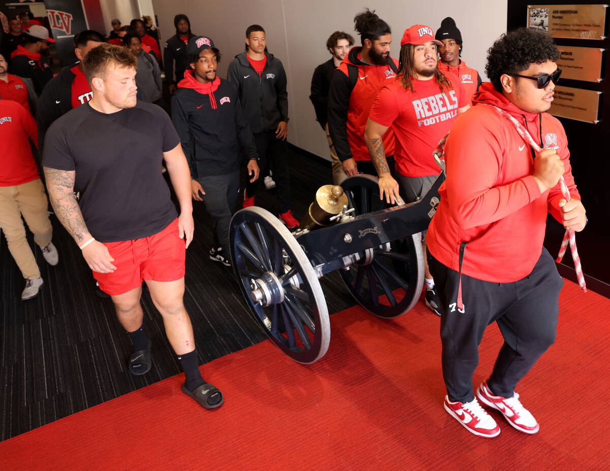 UNLV Football players, including offensive lineman Leif Fautanu, right, roll the Fremont Cannon ...