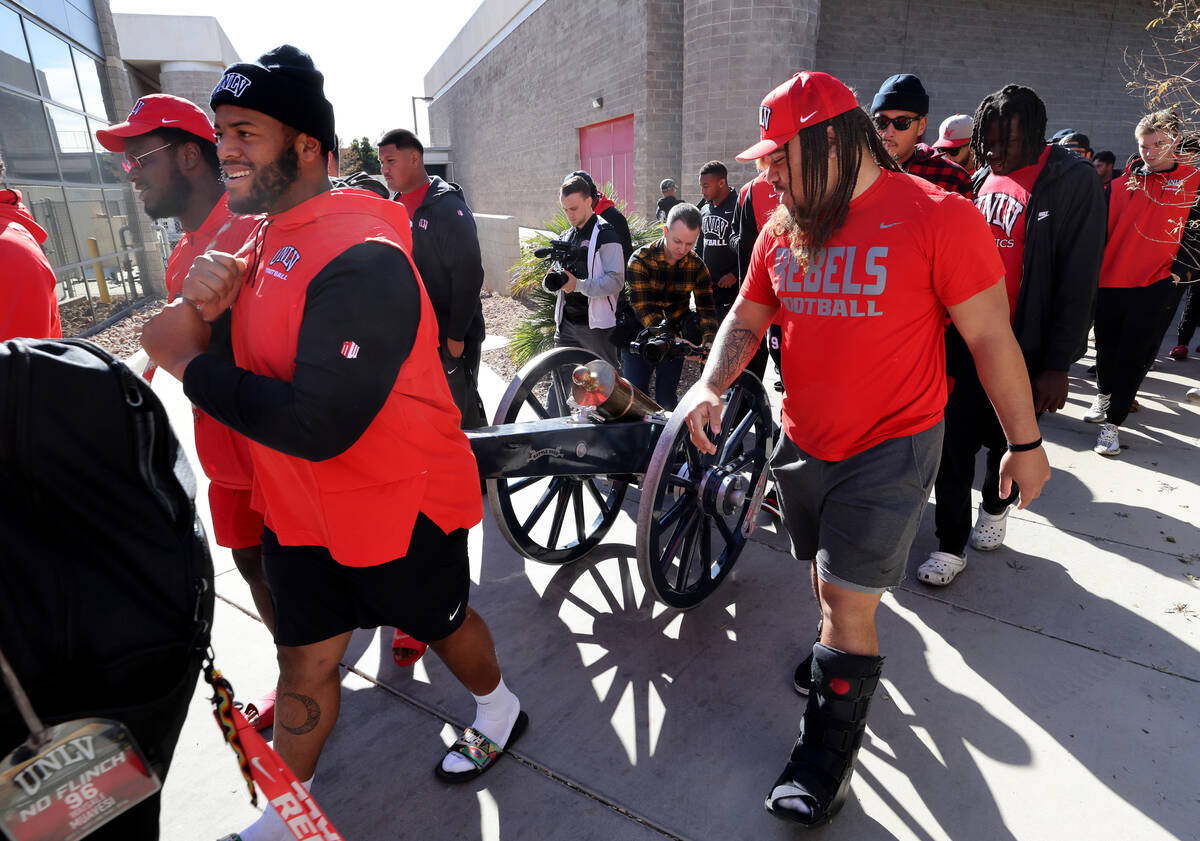 UNLV Football players, including from left, defensive linemen Eliel Ehimare, Tavis Malakius and ...