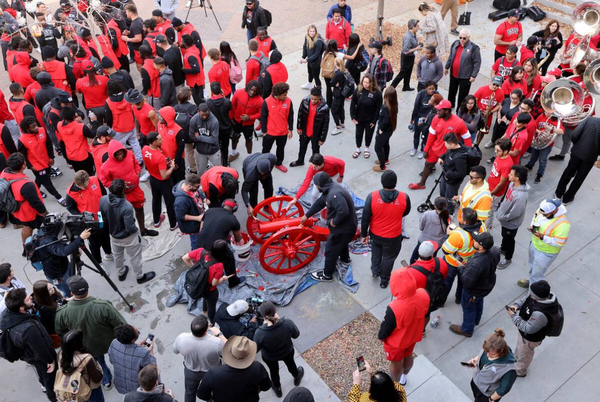 UNLV Football players and students paint the Fremont Cannon red during a celebration on campus ...