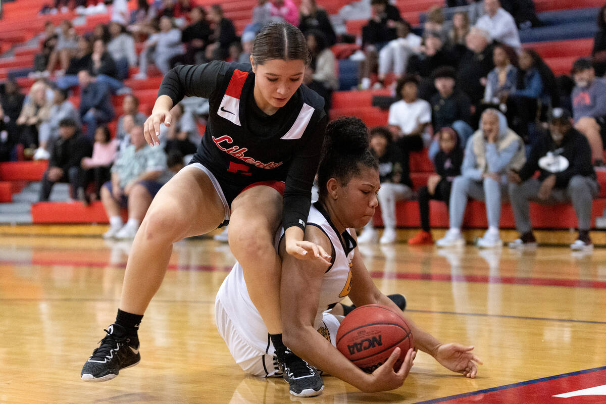 Liberty’s Sydney Chestnut fights for possession of the ball with Clark’s Sarah Up ...