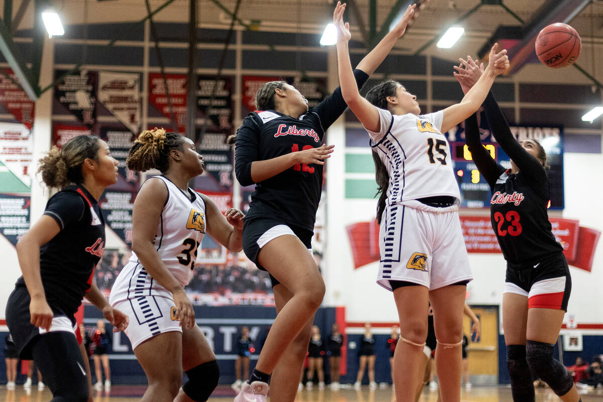 Clark’s Tyler Deporte (15) jumps for the ball against Liberty’s Daisha Peavy (12) ...