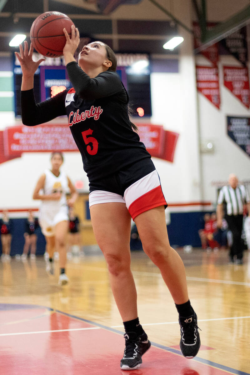 Liberty’s Sydney Chestnut (5) jumps to shoot against Clark during a high school girls ba ...