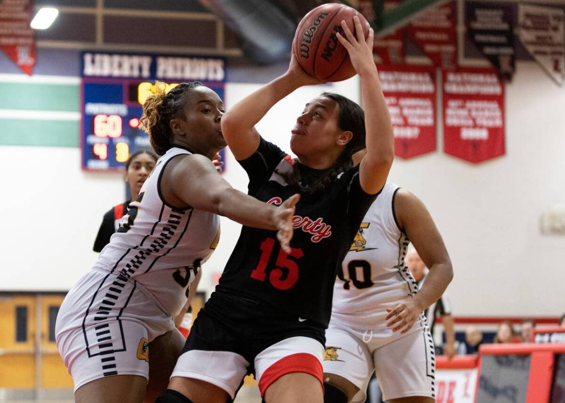 Liberty’s Leilani Harworth (15) attempts to shoot against Clark’s Vicktoryus Byrd ...
