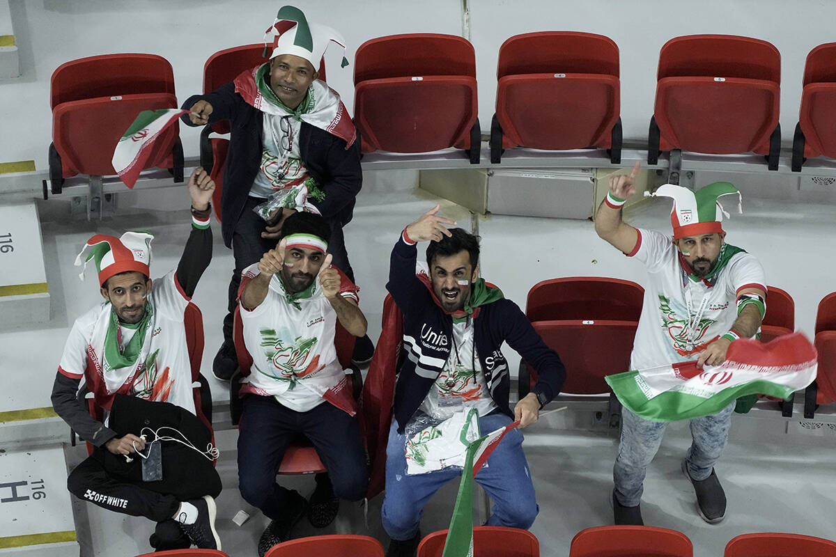 Iran supporters cheer on the stands while waiting for the start of the World Cup group B soccer ...