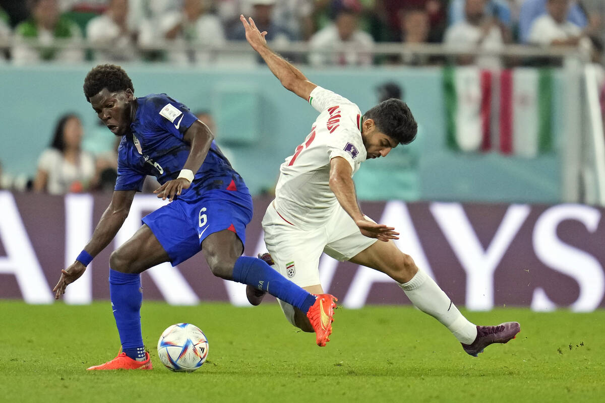 United States' Yunus Musah (6) and Iran's Mahdi Torabi (16) battle for the ball during the Worl ...