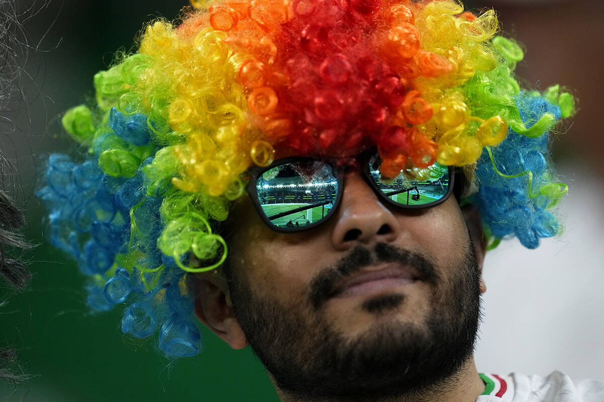 A fan waits for the start of the World Cup group B soccer match between Iran and the United Sta ...