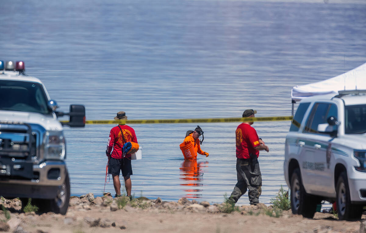 Search and rescue personnel work the shallows as authorities are assessing what were described ...