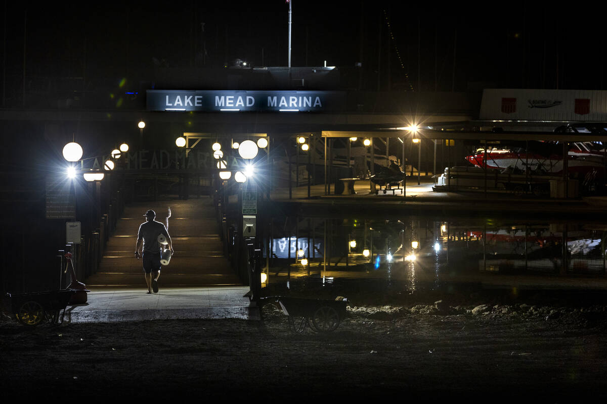 A visitor walks onto the dock at the Lake Mead Marina as the waterline continues to recede alon ...