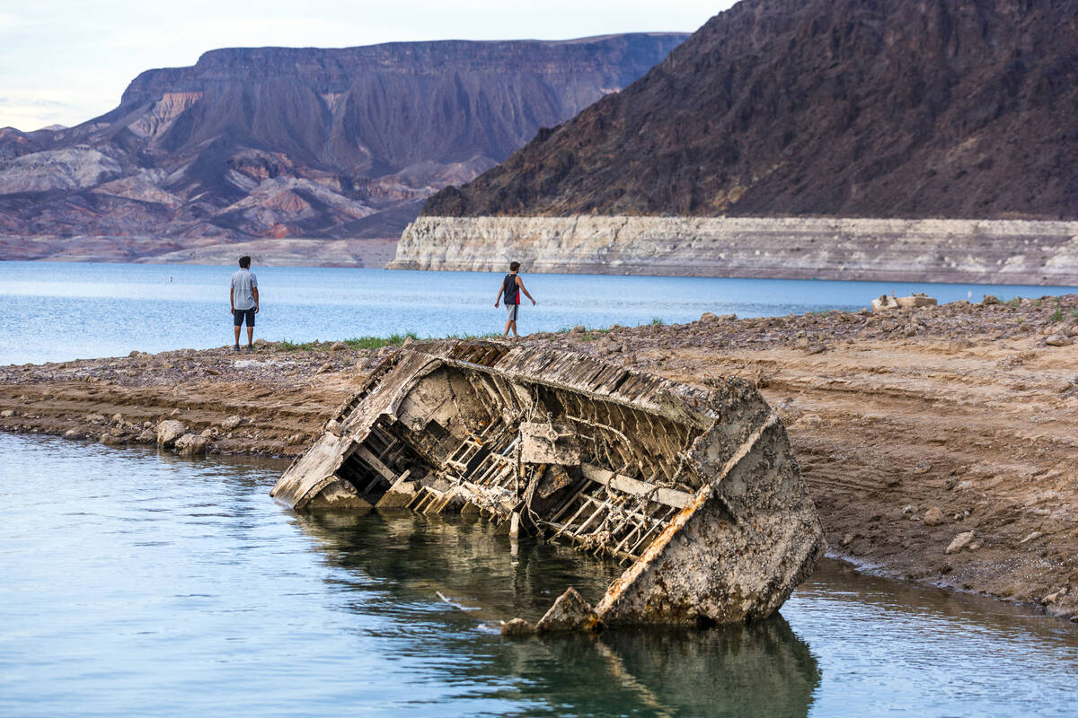 Hikers pass a previously sunken World War II-era Higgins landing craft that once was 185 feet b ...