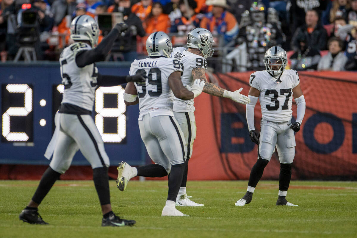 Raiders defensive ends Clelin Ferrell (99) and Maxx Crosby (98) celebrate with cornerback Tyler ...