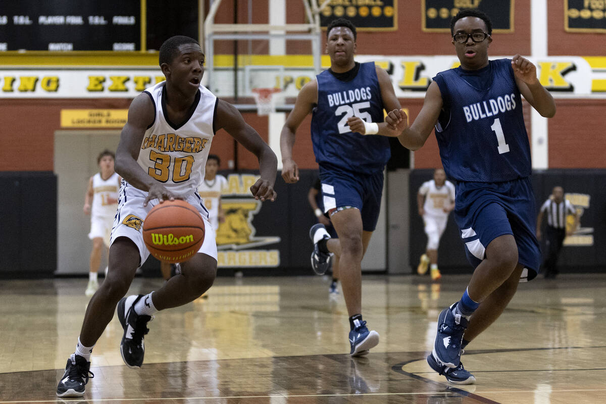 Clark’s John Pembleton (30) dribbles up the court while Centennial’s Tremayne And ...