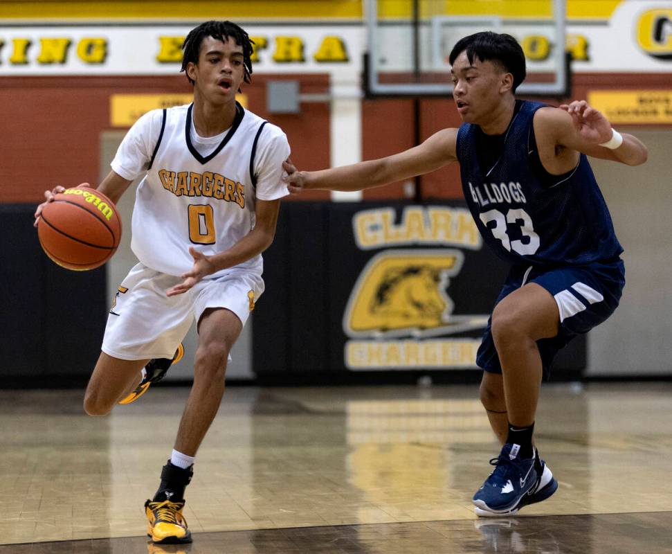 Clark’s Zyon Harris (0) dribbles up the court against Centennial’s Aiden Cute (33 ...