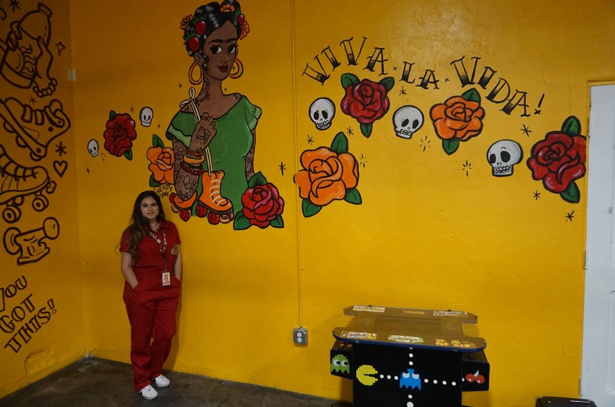 Amanda Quintanilla, owner of Fresa's Skate Shop poses next to a mural done by local artist Cher ...