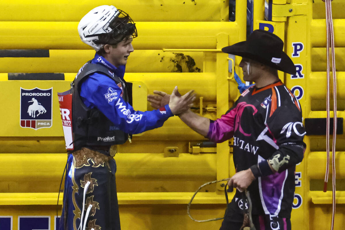 Stetson Wright, of Milford, Utah, left, celebrates after competing in bull riding during the fi ...
