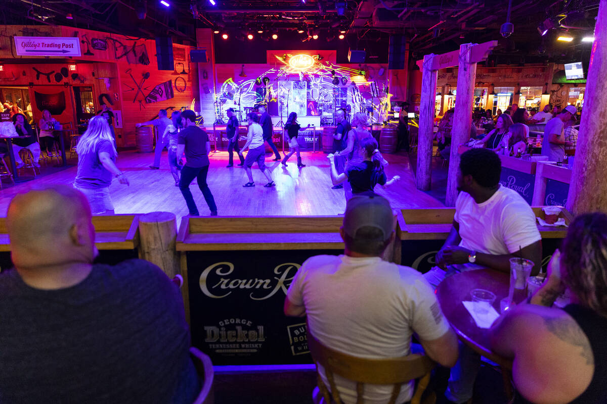 People dance at Gilley's Saloon inside of Treasure Island hotel-casino in Las Vegas, Friday, Au ...