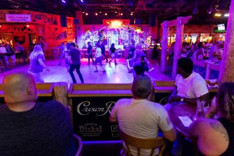 People dance at Gilley's Saloon inside of Treasure Island hotel-casino in Las Vegas, Friday, Au ...