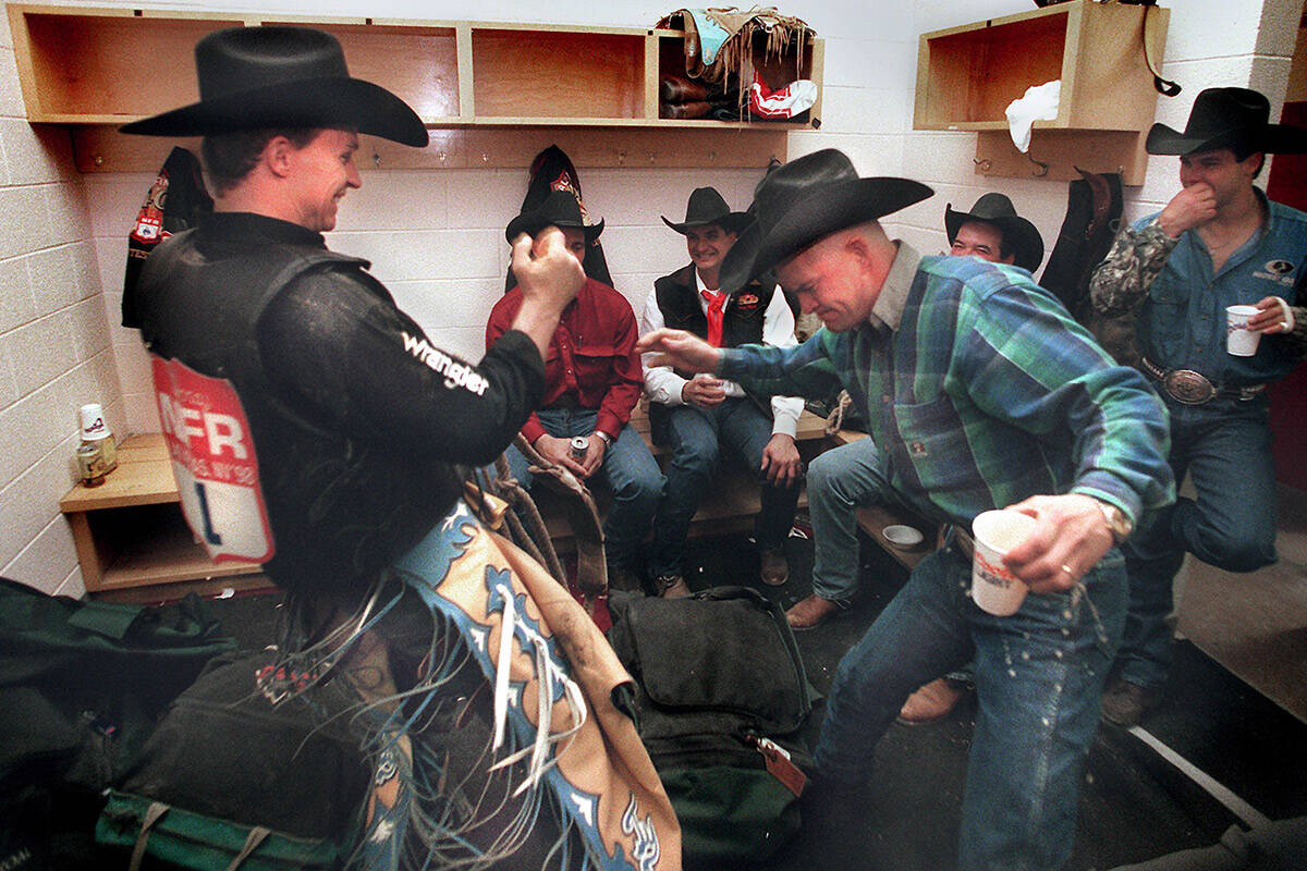 Inside the locker room, world champion cowboy Ty Murray, left, and Larry Sandvick celebrate Mur ...