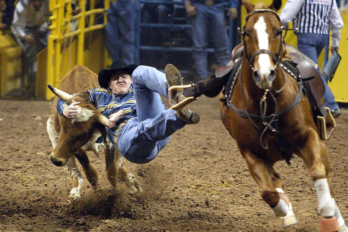 Teddy Johnson of Checotah, Okla., competes in steer wrestling in the first round of the Wrangle ...