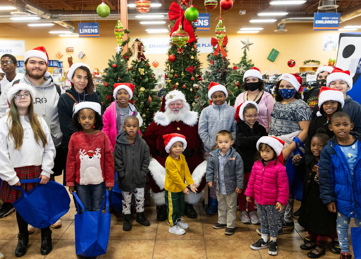 Children pose for a photo with Santa Claus at Goodwill Thrift Store, on Friday, Dec. 2, 2022, i ...