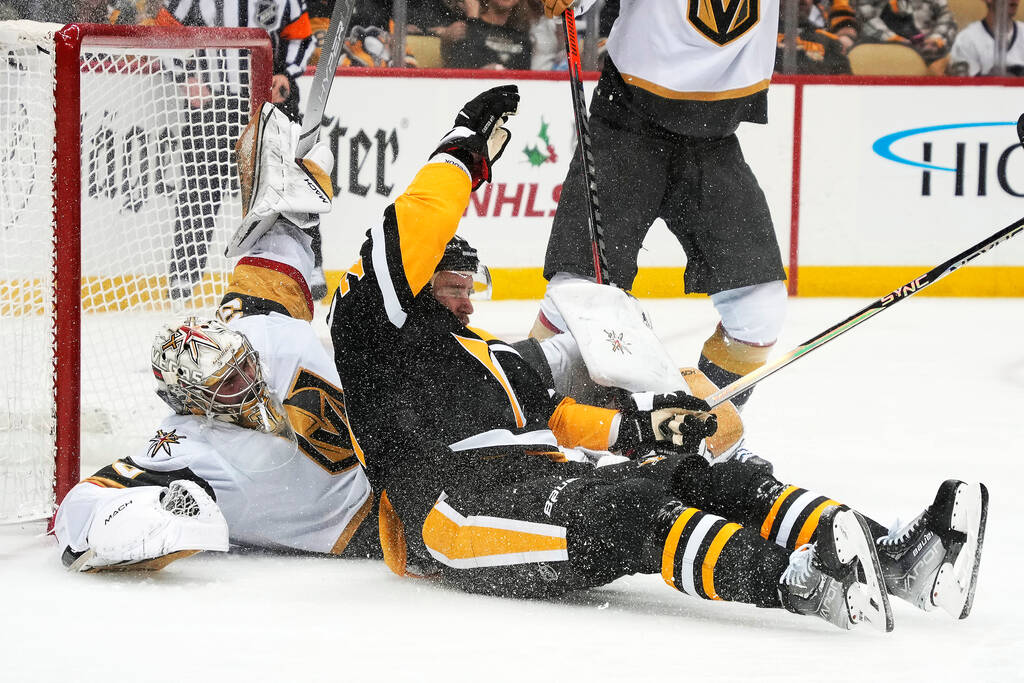 Pittsburgh Penguins' Jeff Carter, center, collides with Vegas Golden Knights goaltender Logan T ...