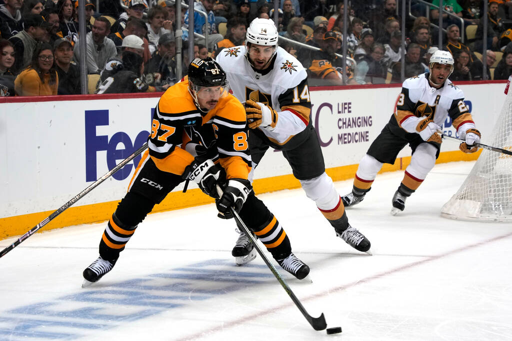 Pittsburgh Penguins' Sidney Crosby (87) sets up a goal with a pass from in front of Vegas Golde ...