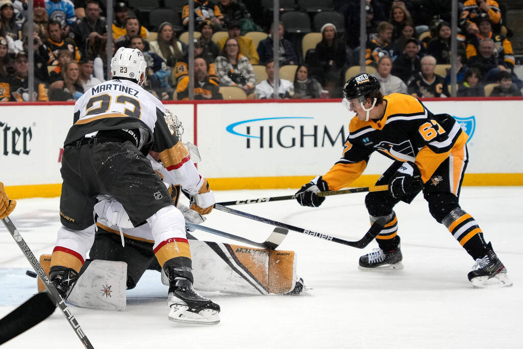 Pittsburgh Penguins' Rickard Rakell (67) shoots behind Vegas Golden Knights goaltender Logan Th ...