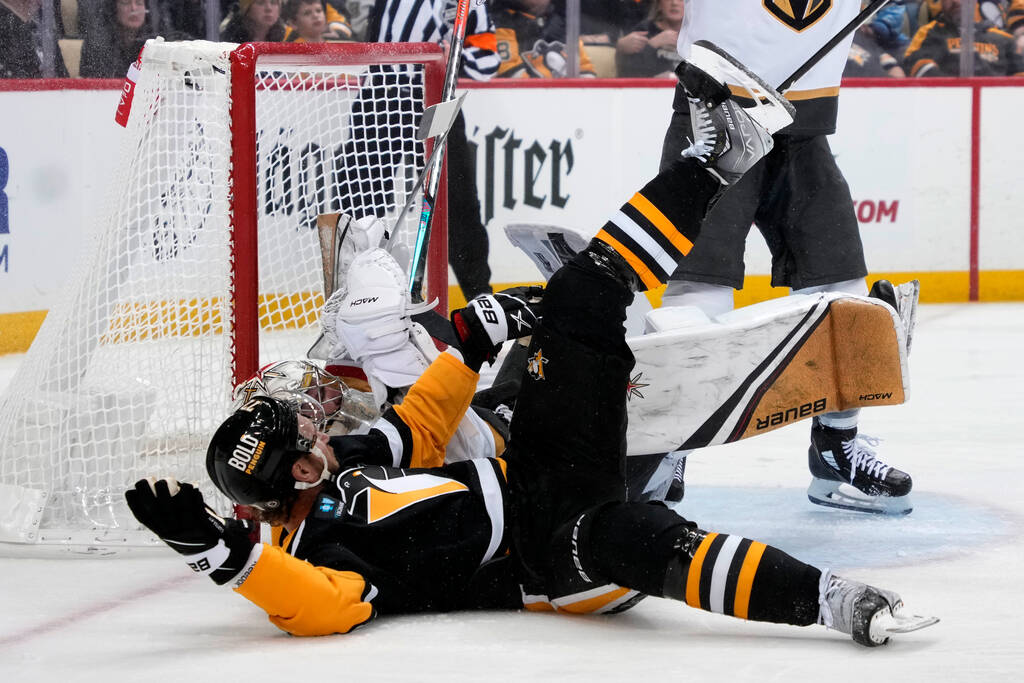 Pittsburgh Penguins' Jeff Carter, front, collides with Vegas Golden Knights goaltender Logan Th ...