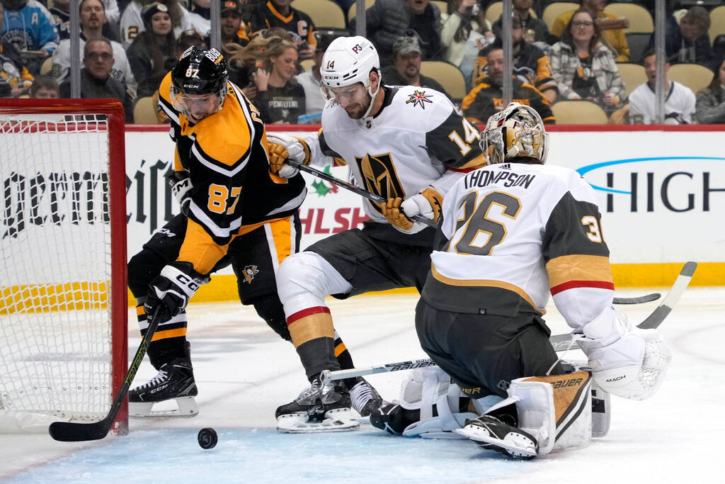 Pittsburgh Penguins' Sidney Crosby (87) tiffs on a loose puck behind Vegas Golden Knights goalt ...