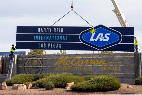 Workers from YESCO change the signage from McCarran International Airport to Harry Reid at Kova ...