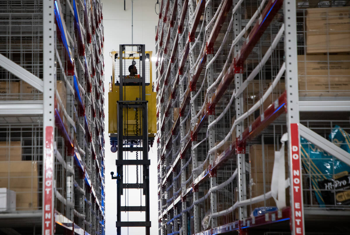 An employee uses a forklift to reach heavier items to be delivered in the narrow aisle section ...