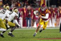 Southern California quarterback Caleb Williams, right, runs the ball as Notre Dame safety Xavie ...