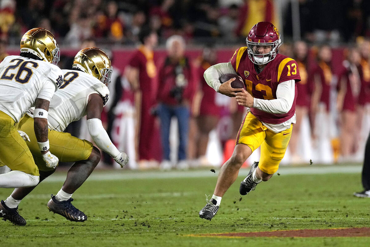 Southern California quarterback Caleb Williams, right, runs the ball as Notre Dame safety Xavie ...