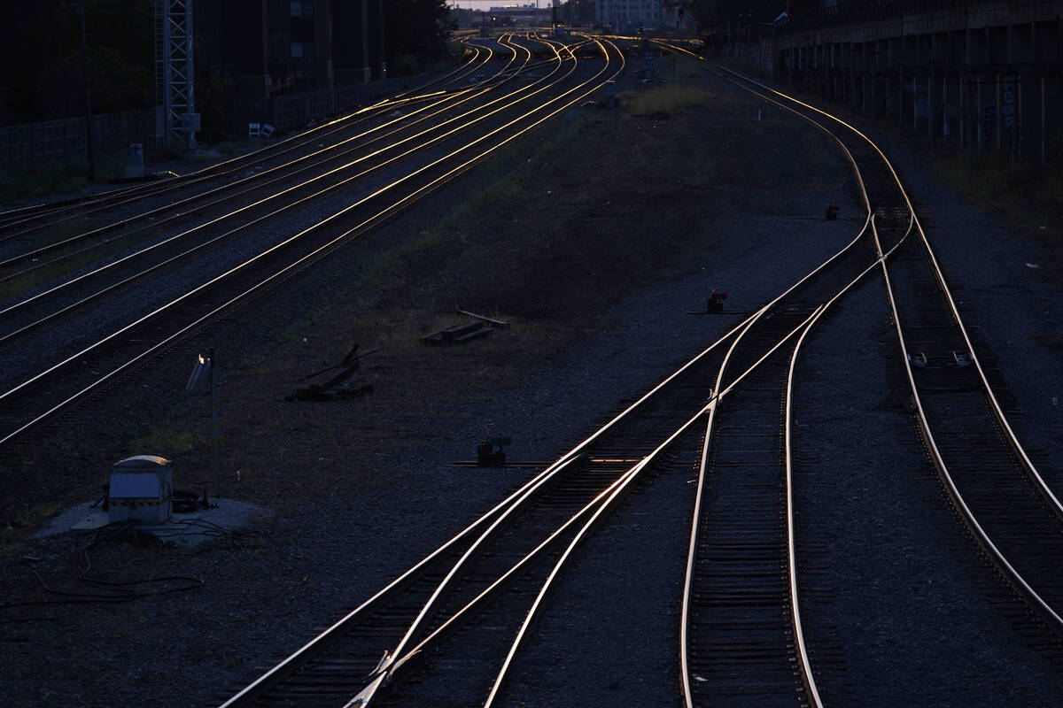 Train tracks headed west reflect the sun setting near Chicago's Union Station, Sept. 14, 2022. ...