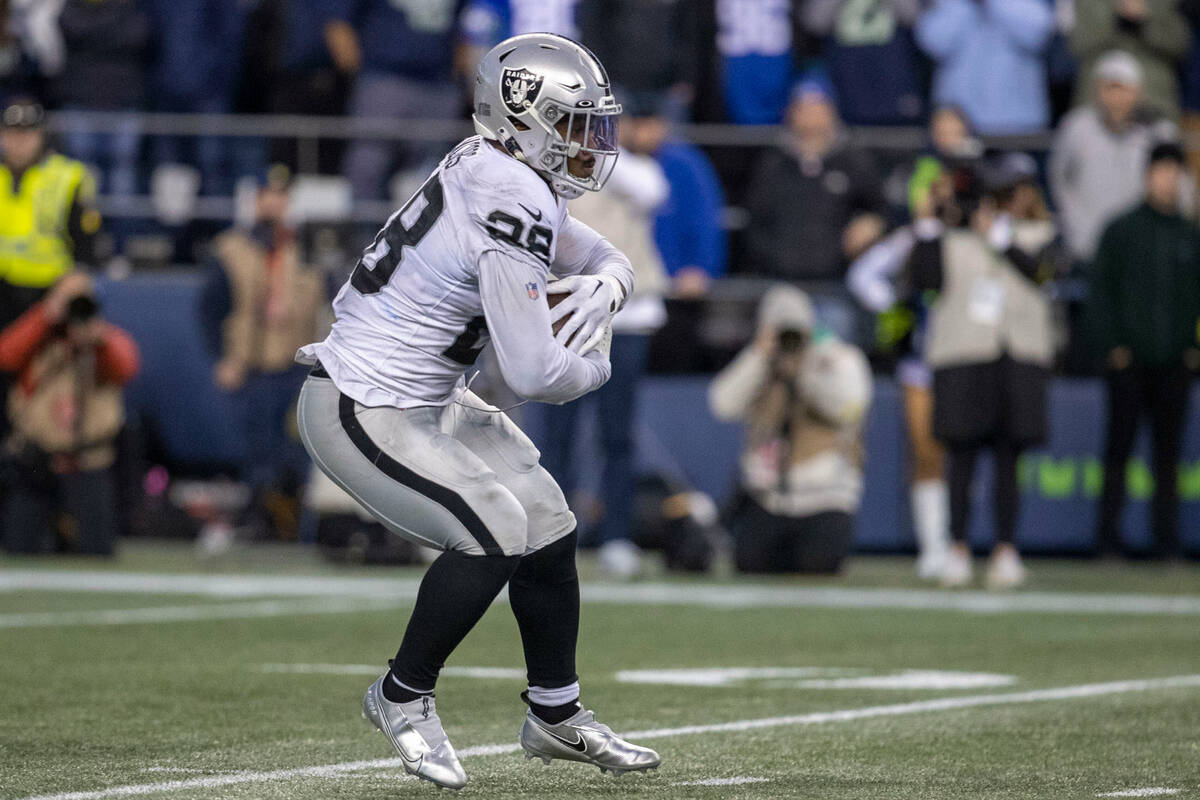 Raiders running back Josh Jacobs (28) looks for room to run before breaking free on a 86-yard t ...