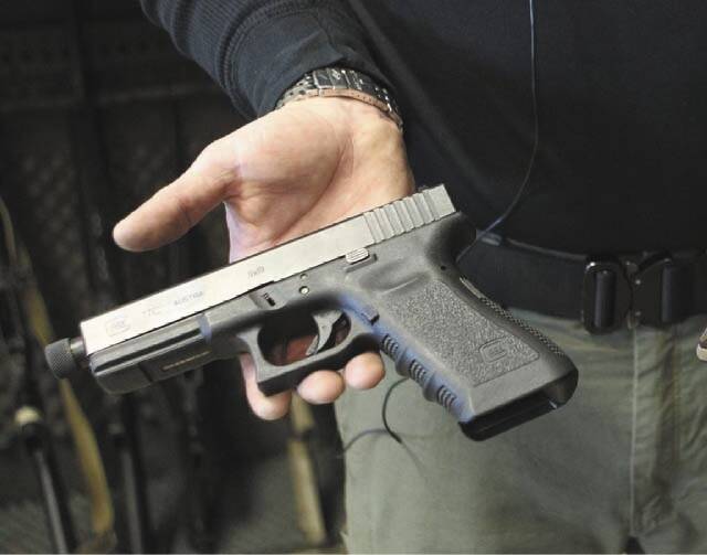 Matt Supnick holds a Glock semi-automatic pistol in Las Vegas on Wednesday, Jan. 16, 2013. (Jer ...
