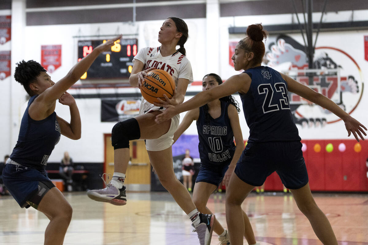 Las Vegas’ Layla Faught, center, shoots against Spring Valley’s Mia Ervin, left, ...