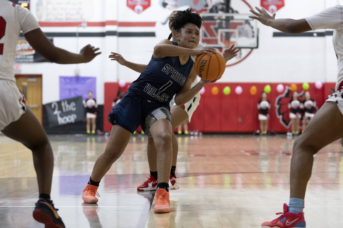Spring Valley’s Mia Ervin (1) looks to pass while Las Vegas guards her during a girls hi ...